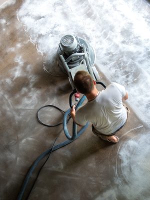 Builder workers working with concrete floor grinding machine, concrete floor repair Builder workers working with concrete floor grinding machine, concrete floor repair